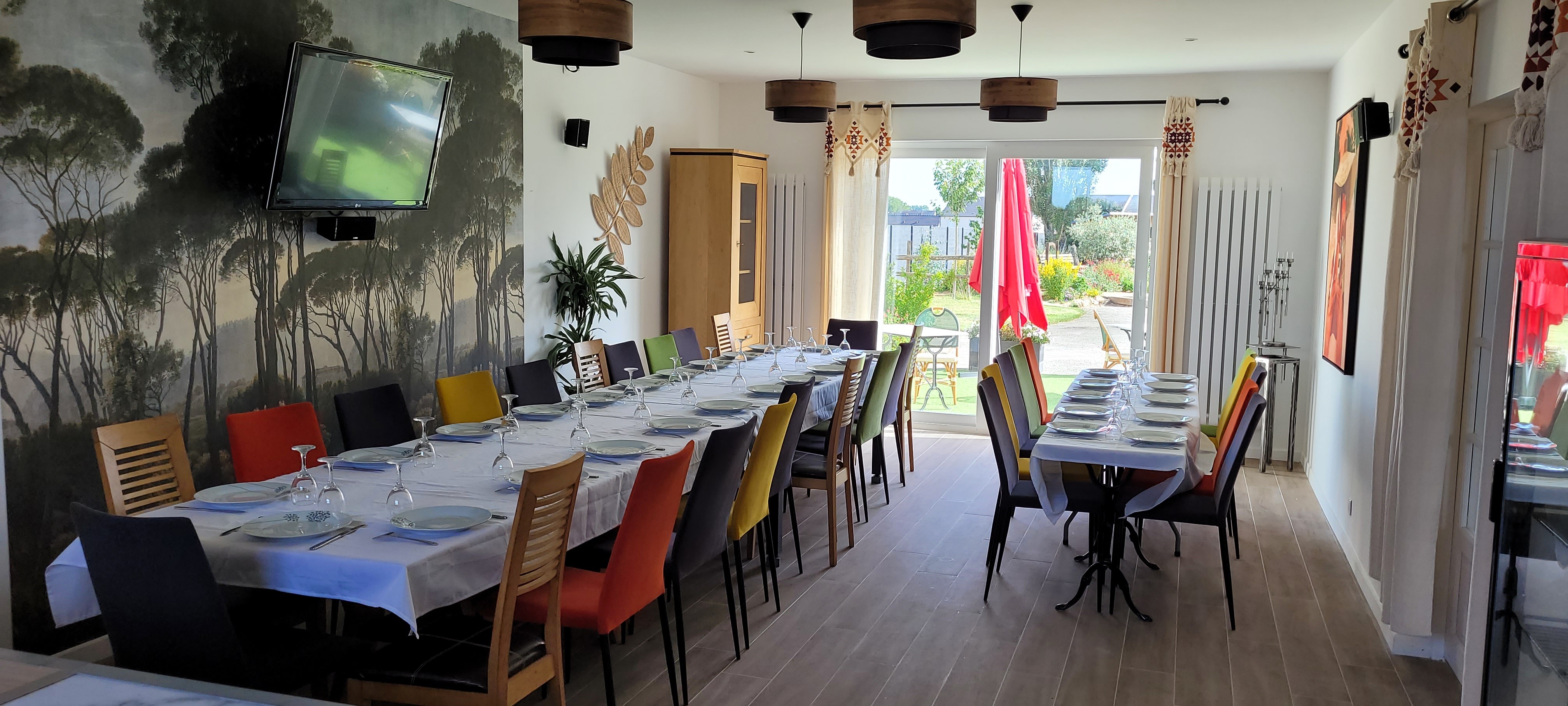 Salle de réception dressée pour un repas de groupe avec fresque murale