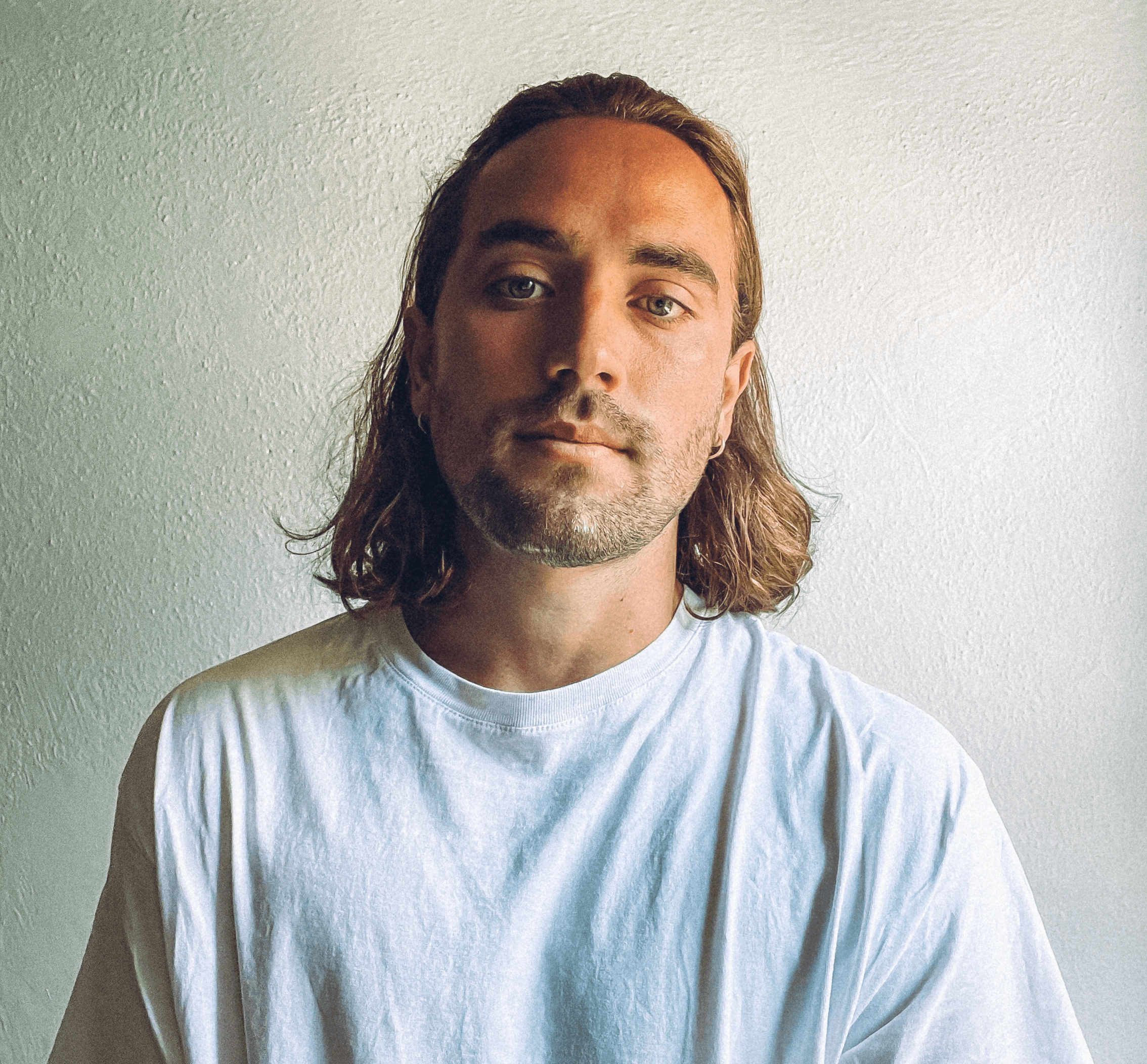 Profile portrait of a man in a white shirt against a light background