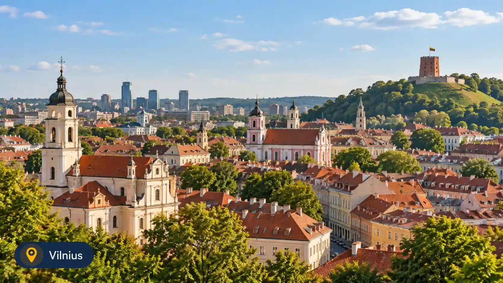 Panoramic daytime view of Vilnius Old Town in Lithuania with historic red rooftops, church towers and Gediminas Castle Tower on the hill.