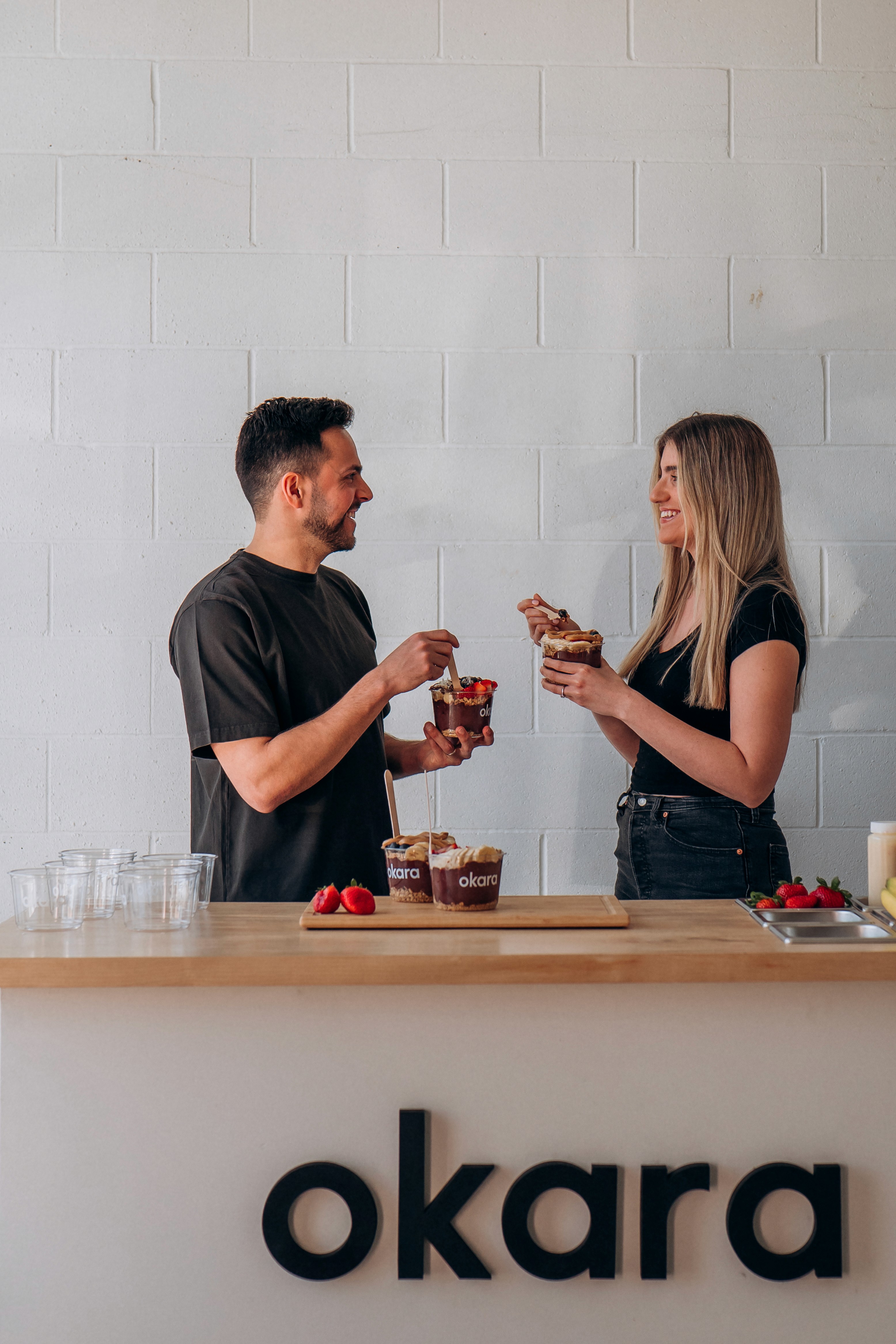 two people in a workspace working on their laptops