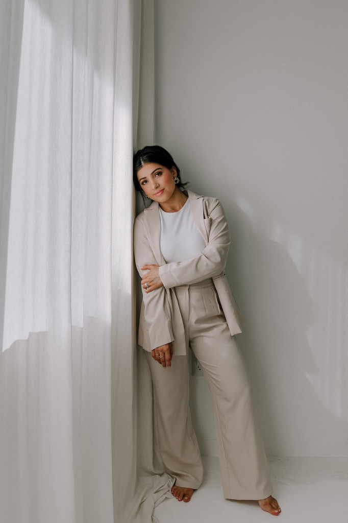 Woman standing by window in natural light studio