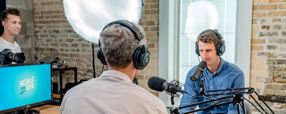 Podcast recording session with two hosts and technical crew in a modern studio setup.