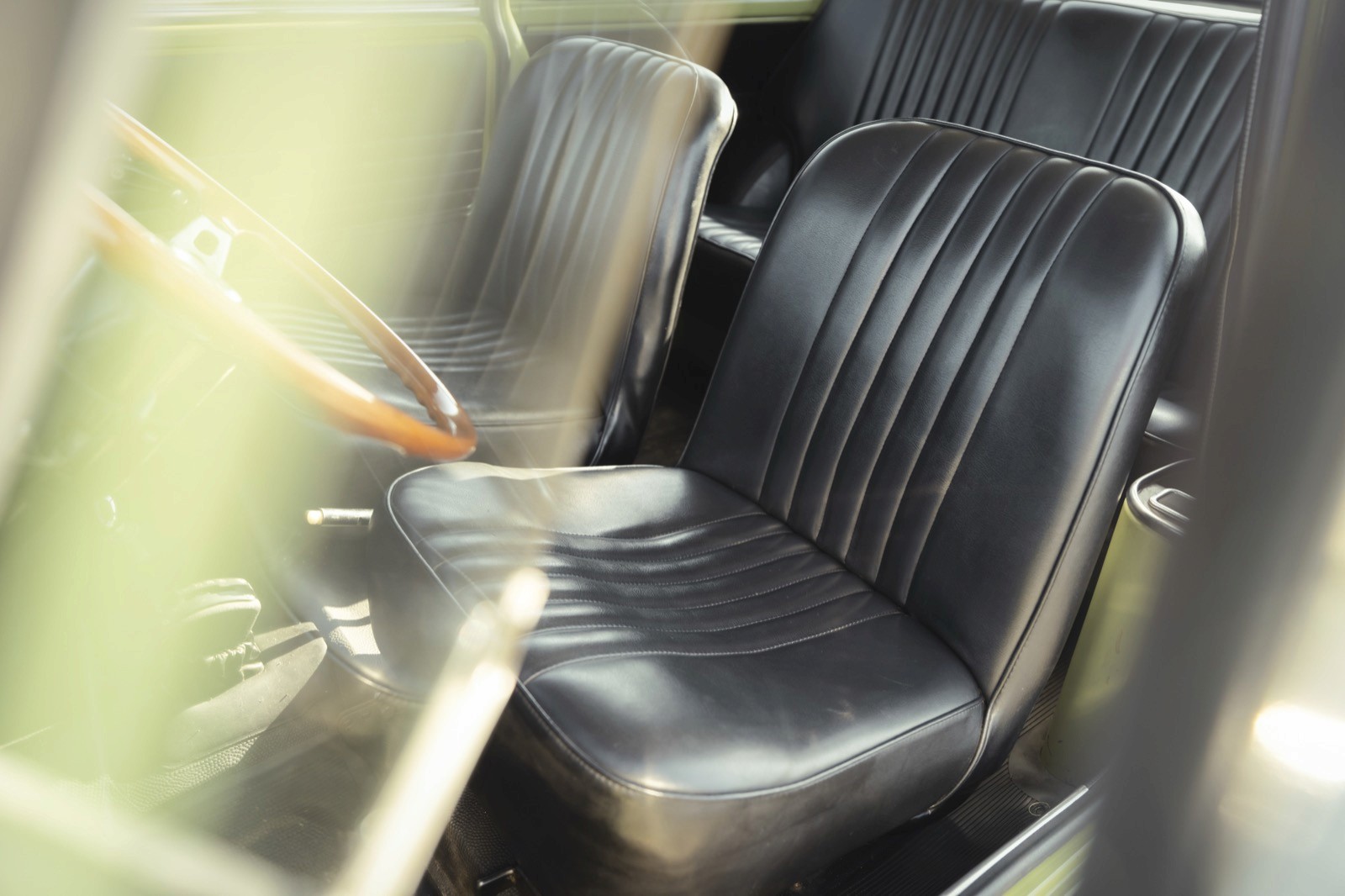 Close-up of a black leather seat with a quilted design in a vehicle interior setting.