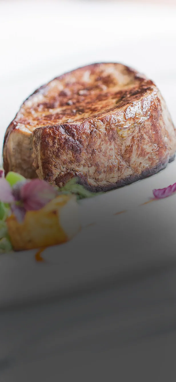 A dimly lit table set with assorted dishes, candles, and an atmospheric smoke, creating a mysterious vibe.