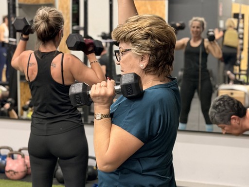 woman sitting on yoga mat with in front of girl during daytime