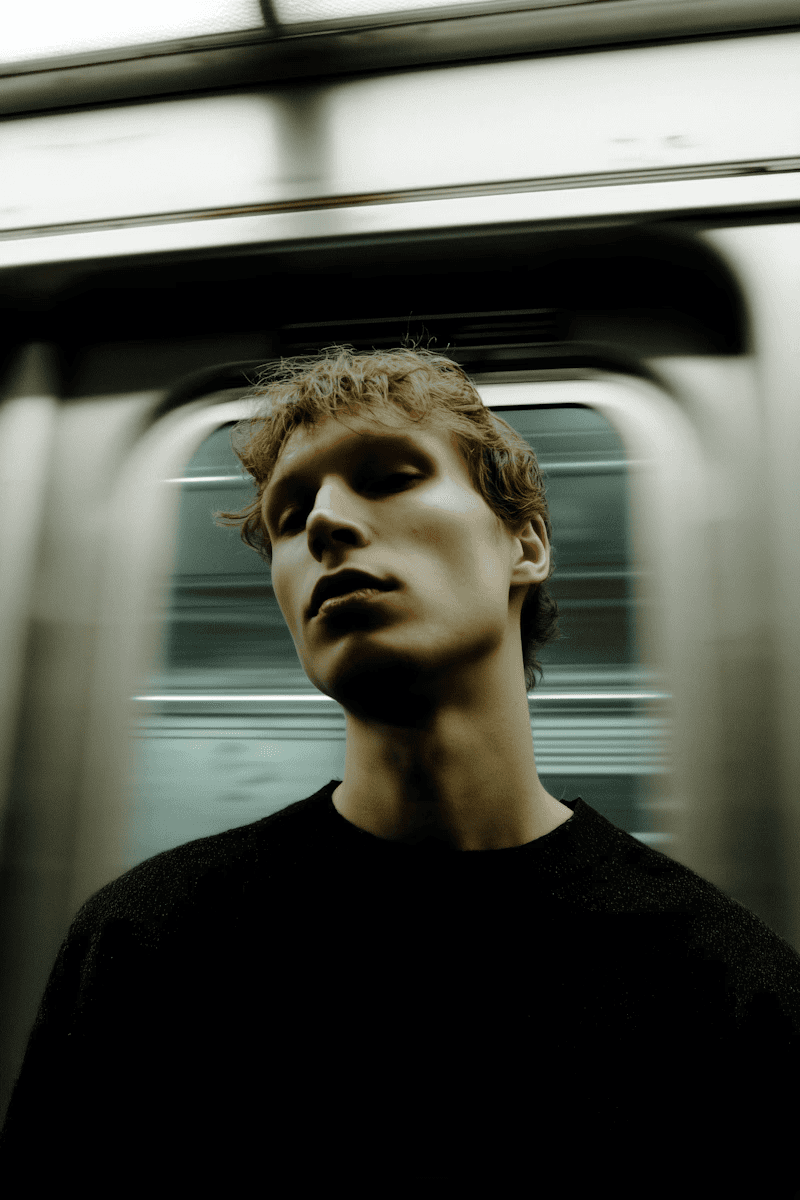 A youth near a subway train with a blurred background