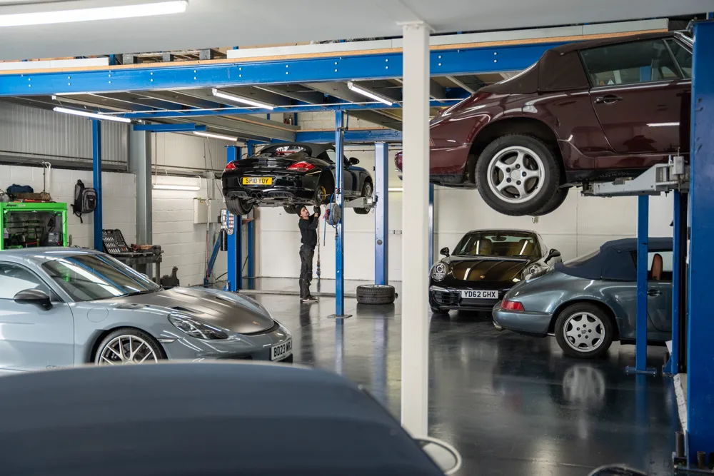 hc porsche mechanic working under car