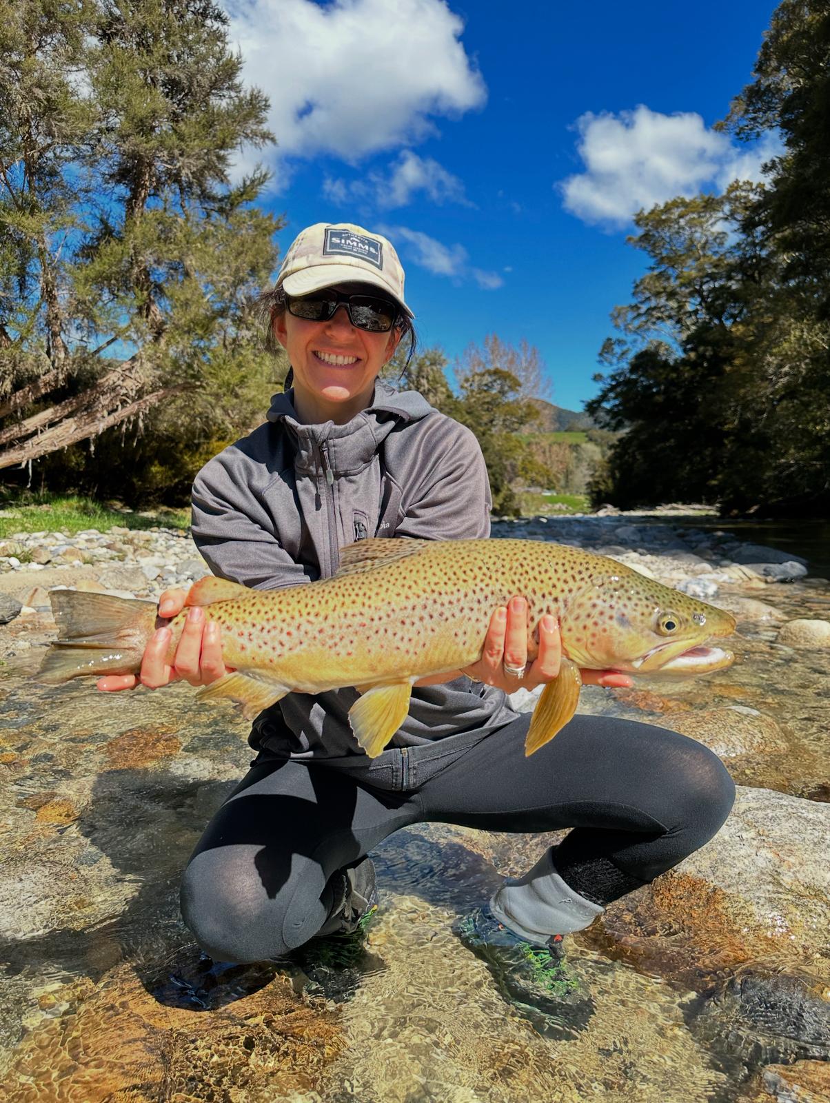 Fly fisherman casting into a clear South Island stream in New Zealand
