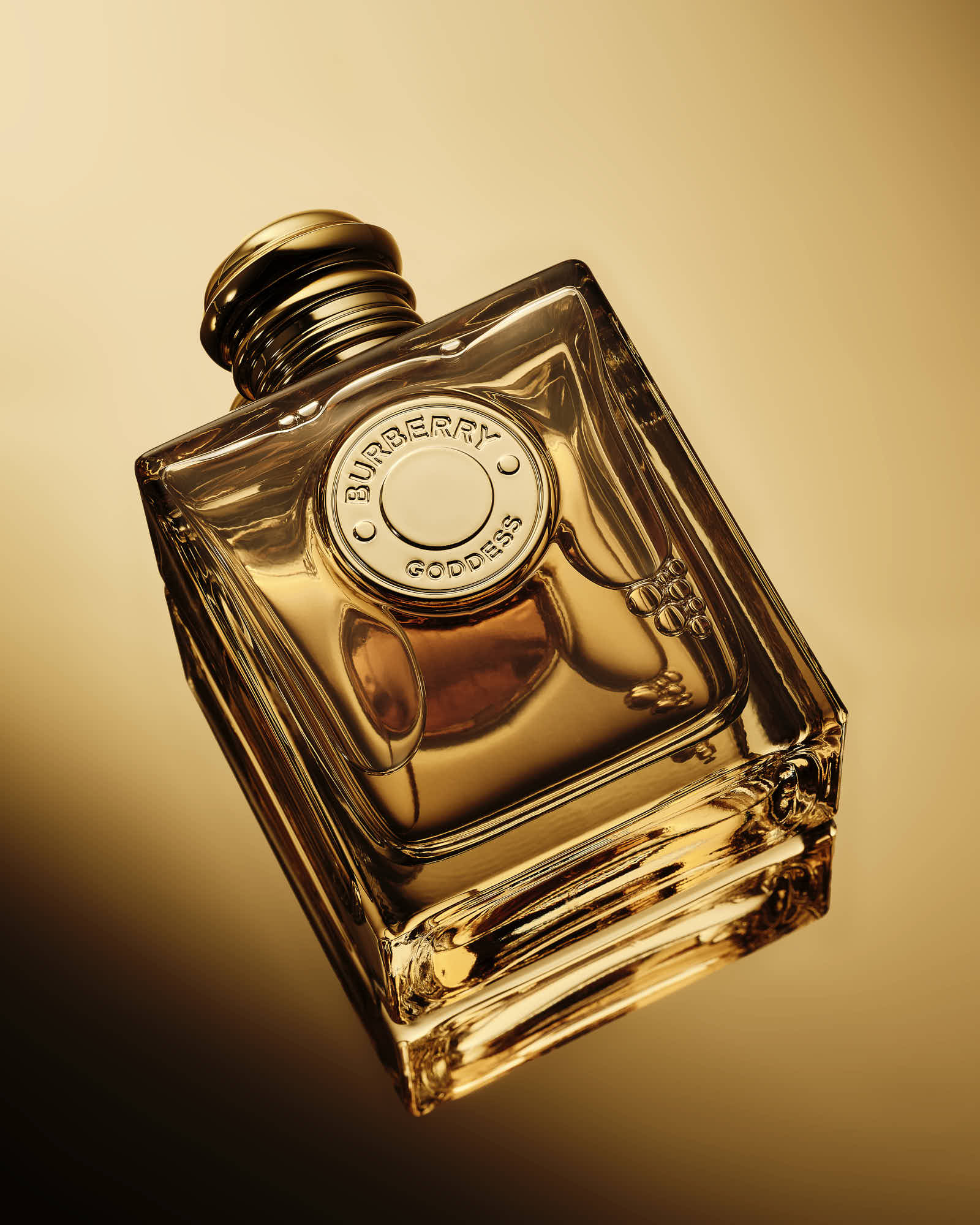 Luxury Burberry Goddess perfume bottle on gold background.