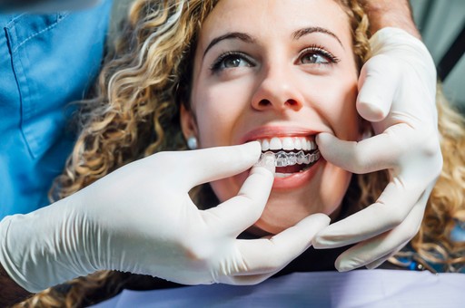 The client is testing her customized Invisalign in Dubai aligners with the help of a professional dentist from Invisalign Center.