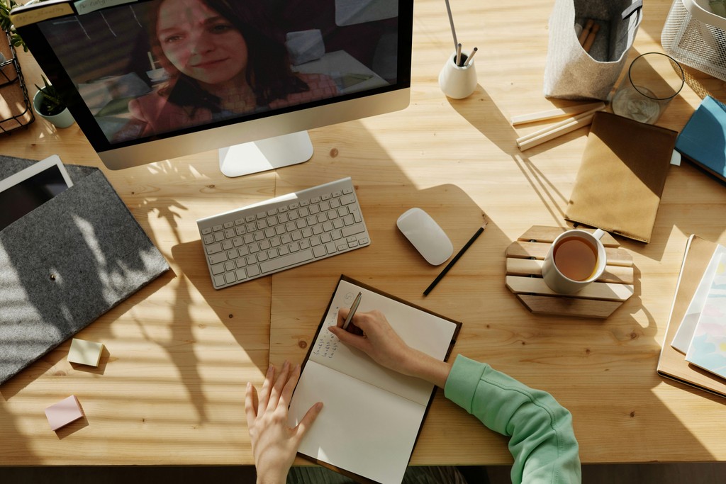 Person attending a virtual meeting, taking notes to improve accountability and demonstrate how they took responsibility for a mistake.