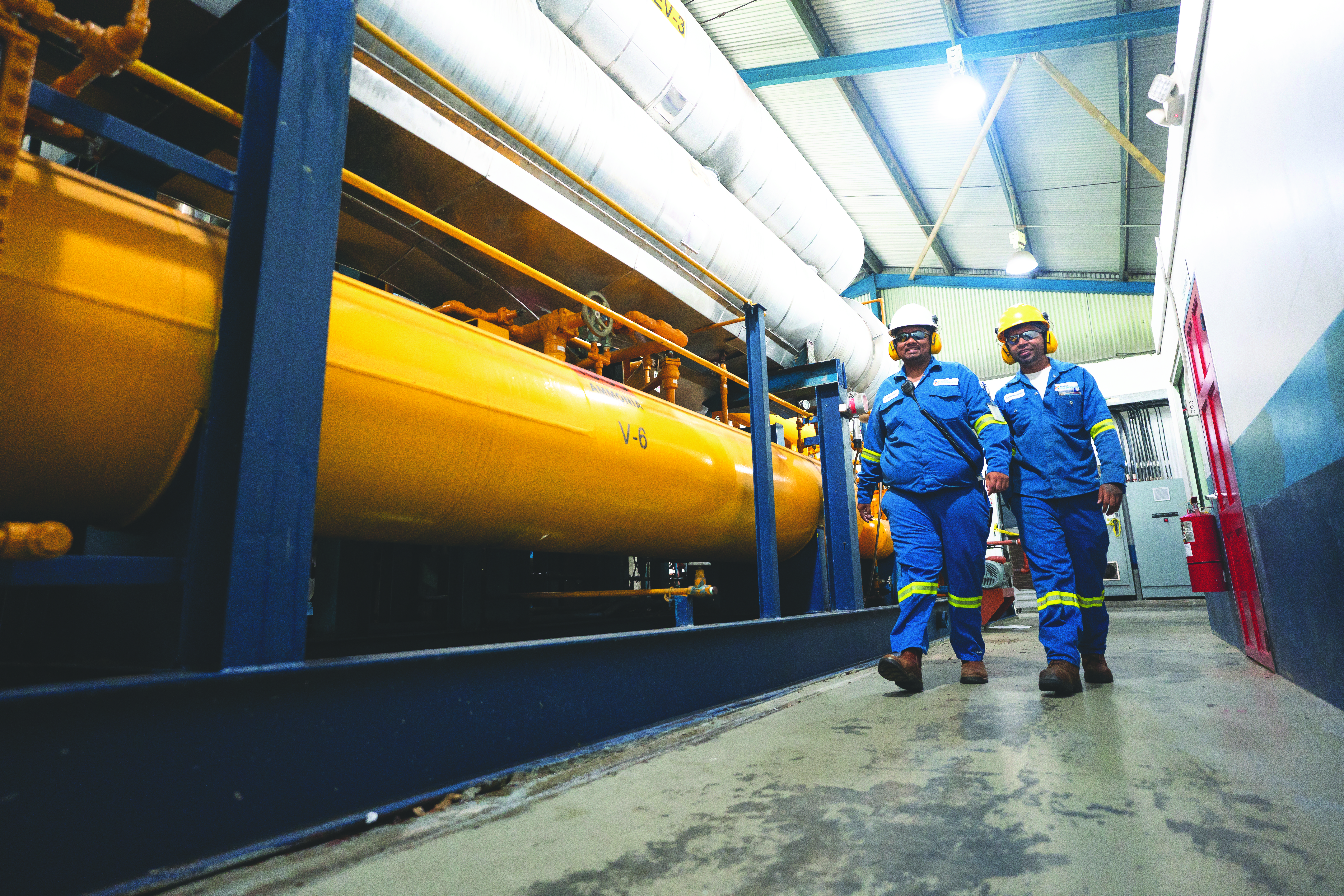 Two gas workers inside a factory building