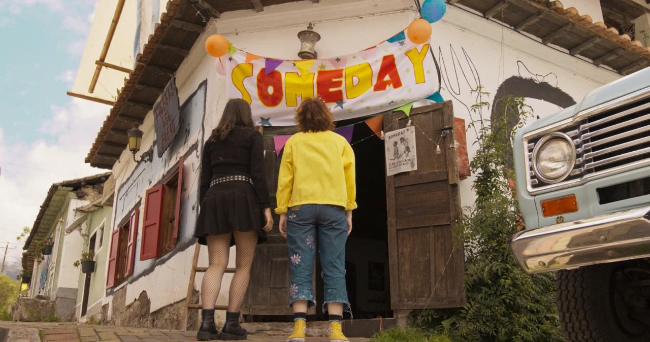 View of the French countryside through a stone villa’s open living room, with sofas and trees framing the scene