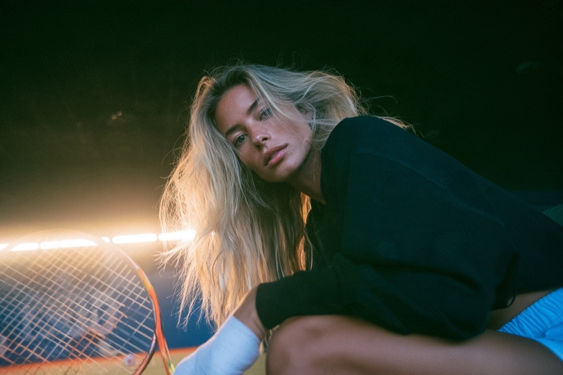 KI-Visual: Tennisspielerin mit Schläger im Gegenlicht