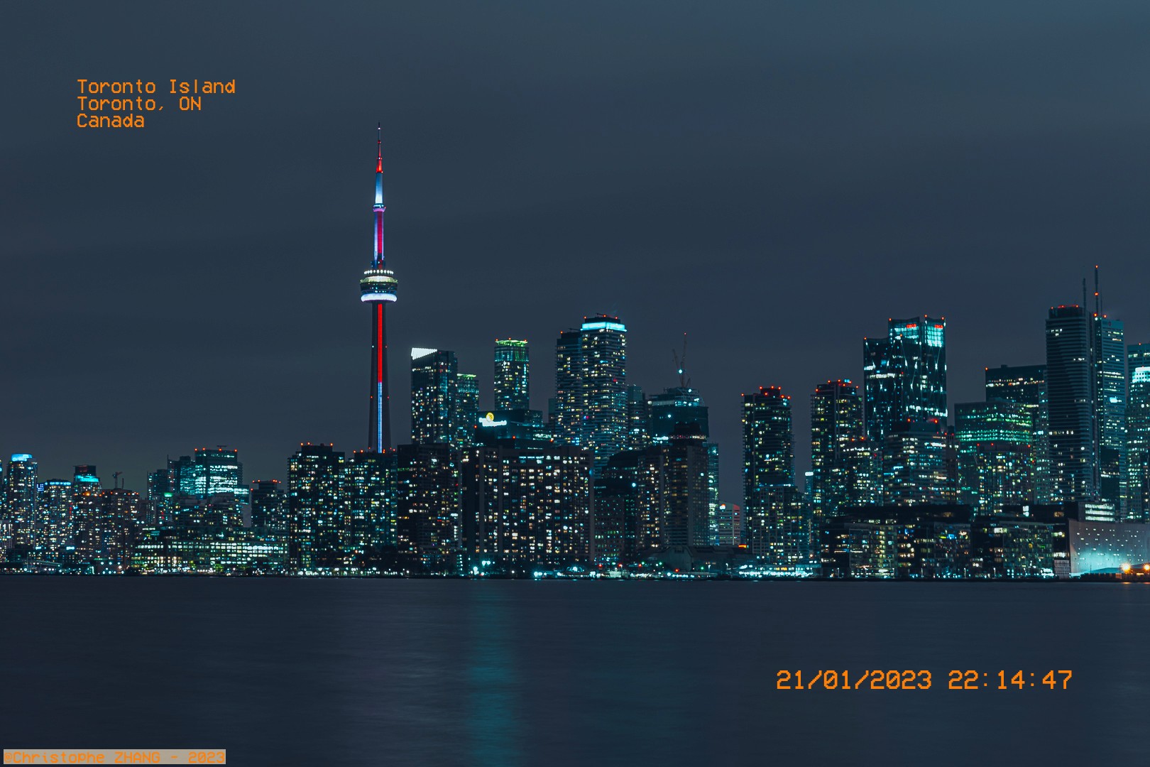 Toronto de nuit, avec la tour CN dominant les gratte-ciel scintillants.