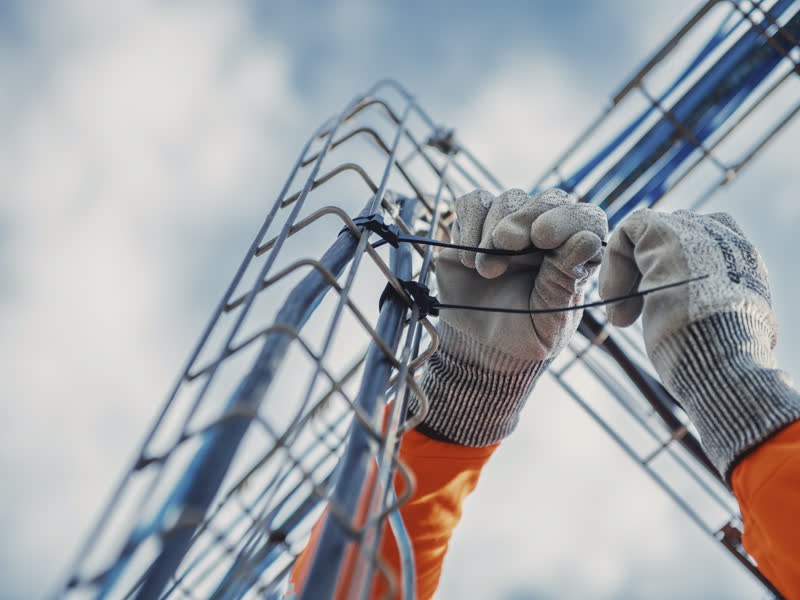 Électricien travaillant en hauteur sur une charpente métallique