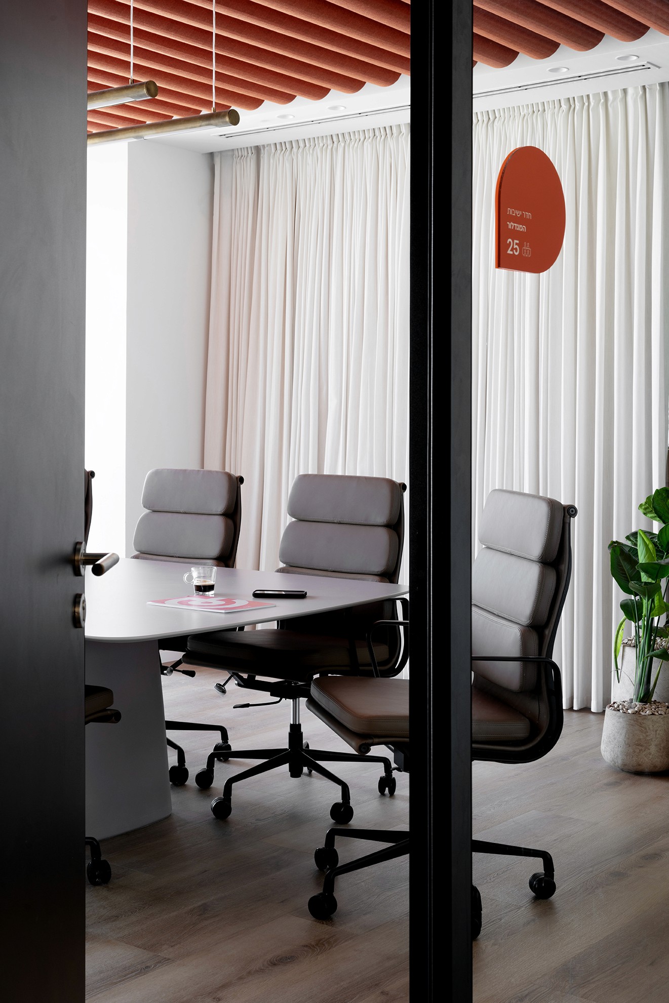 חדר עבודה אינטימי עם וילונות אקוסטיים לפרטיות וריהוט משרדי מינימליסטי בקווים נקיים