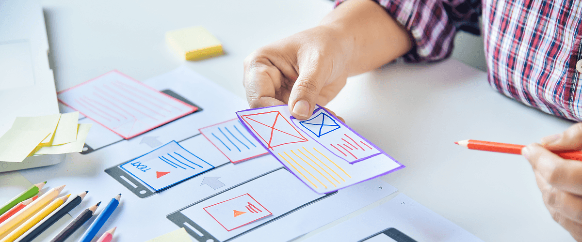 A hand sketching out animated frames for a smartphone interface, illustrating the impact of animation in modern advertising.