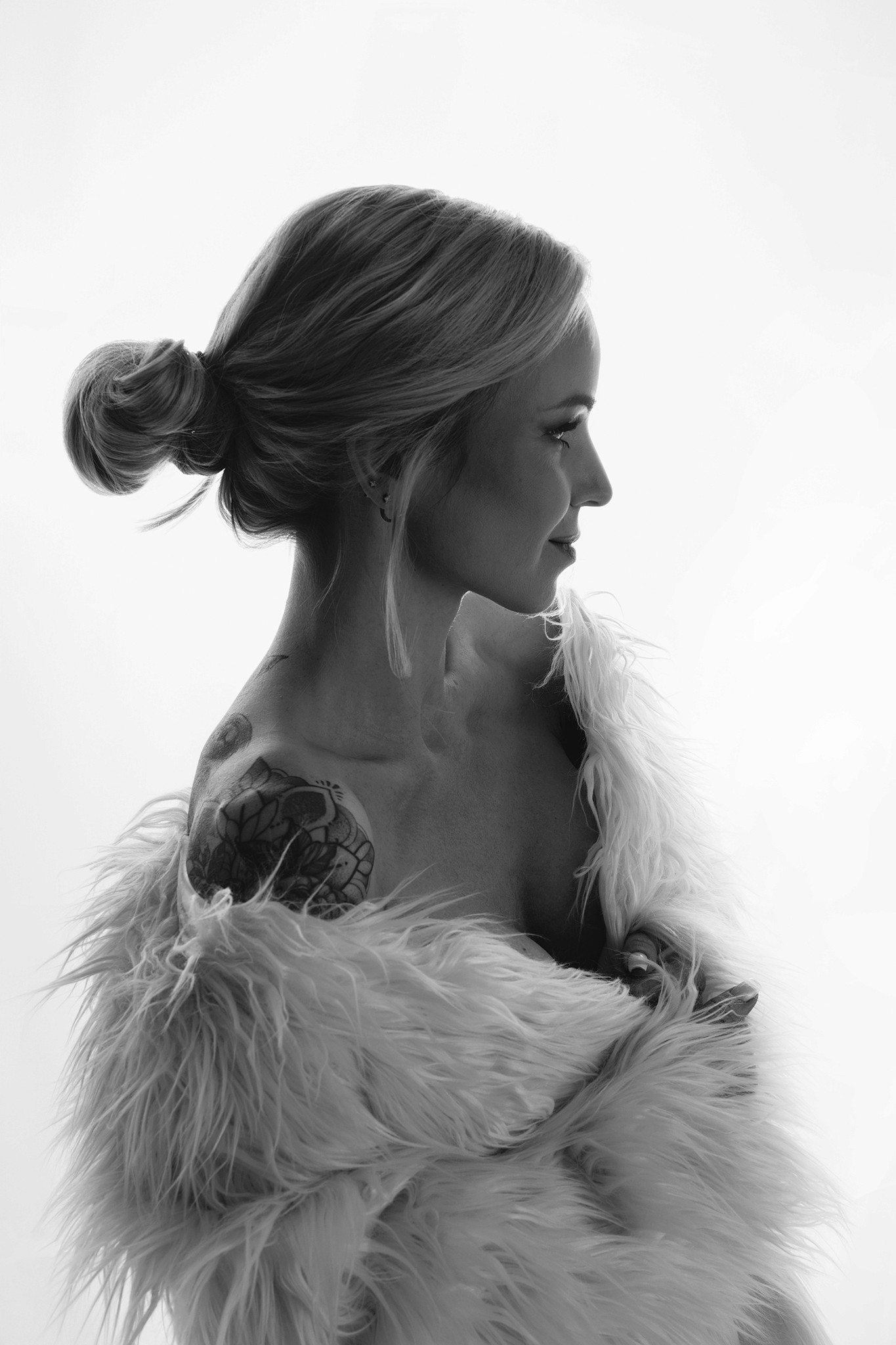 Agnieszka Czyzkowska kobiece sesje fotograficzne Warszawa portret kobiety z tatuazem w futrzanym plaszczu czarno-biale