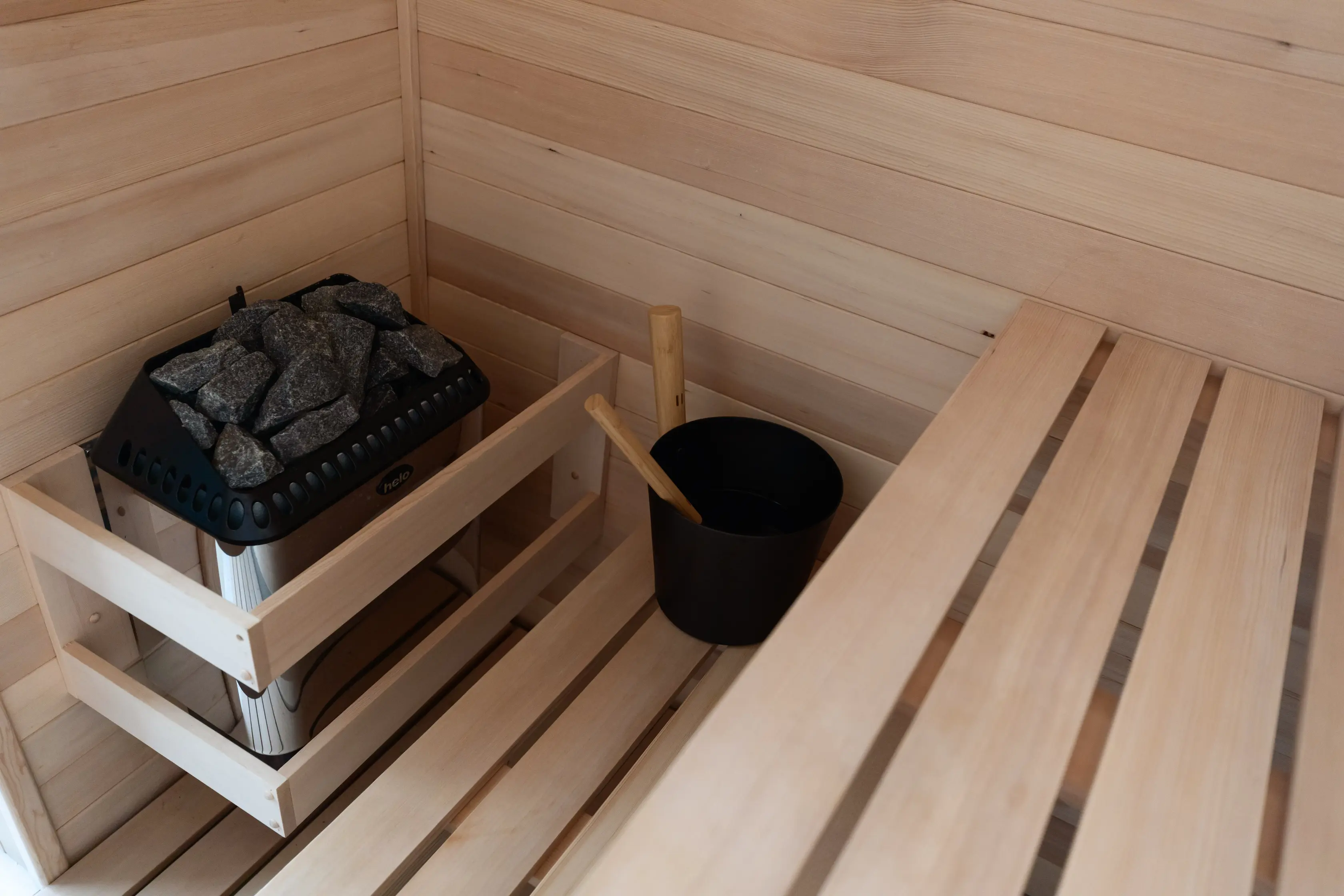 Outdoor lounge under a wooden pergola, draped linen curtains, beige cushions, ocean backdrop, palm shadows dancing on the walls, serene luxury.