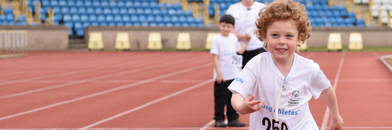Fragile X banner, child running on running tracks smiling