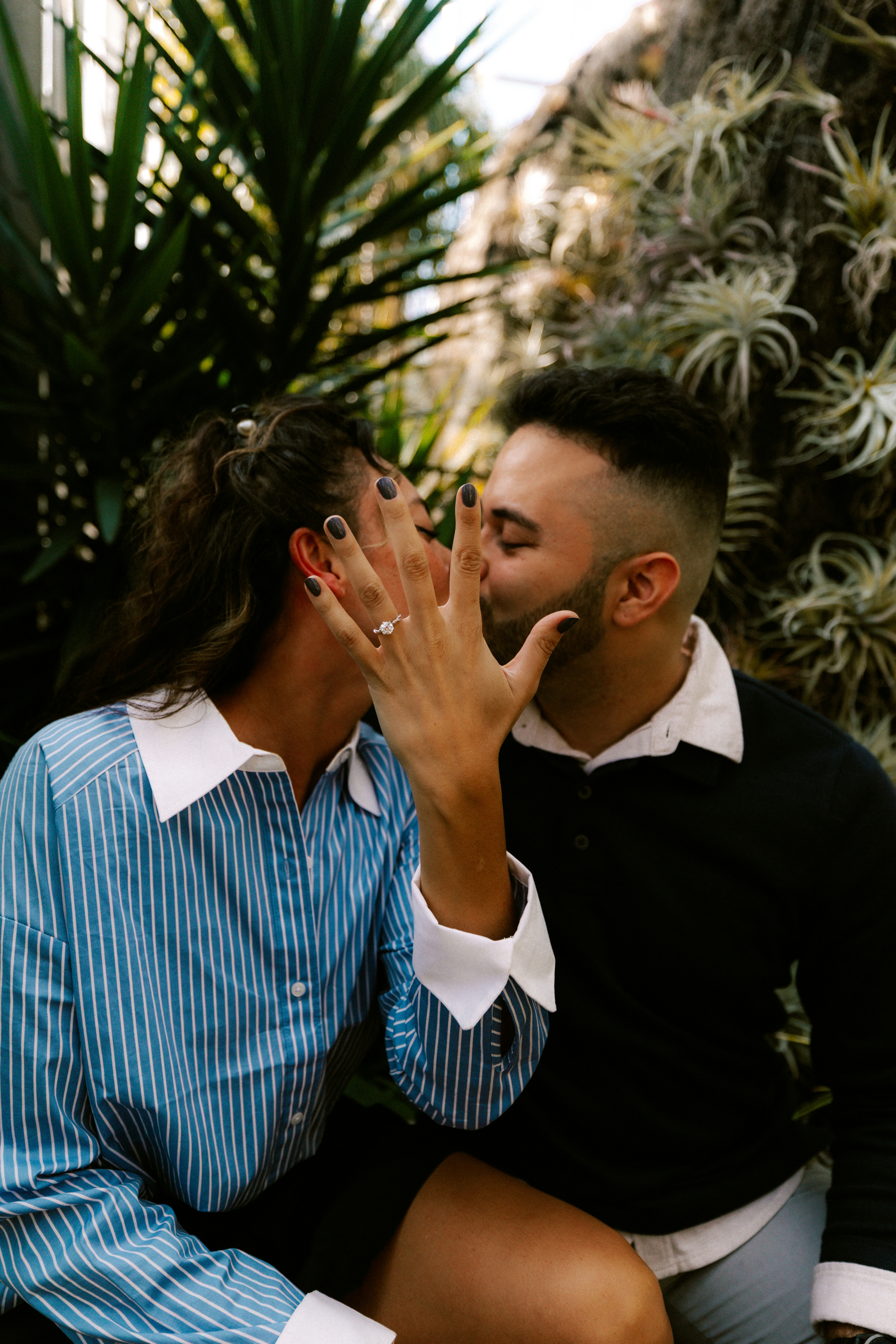 Couple kissing, showing engagement ring
