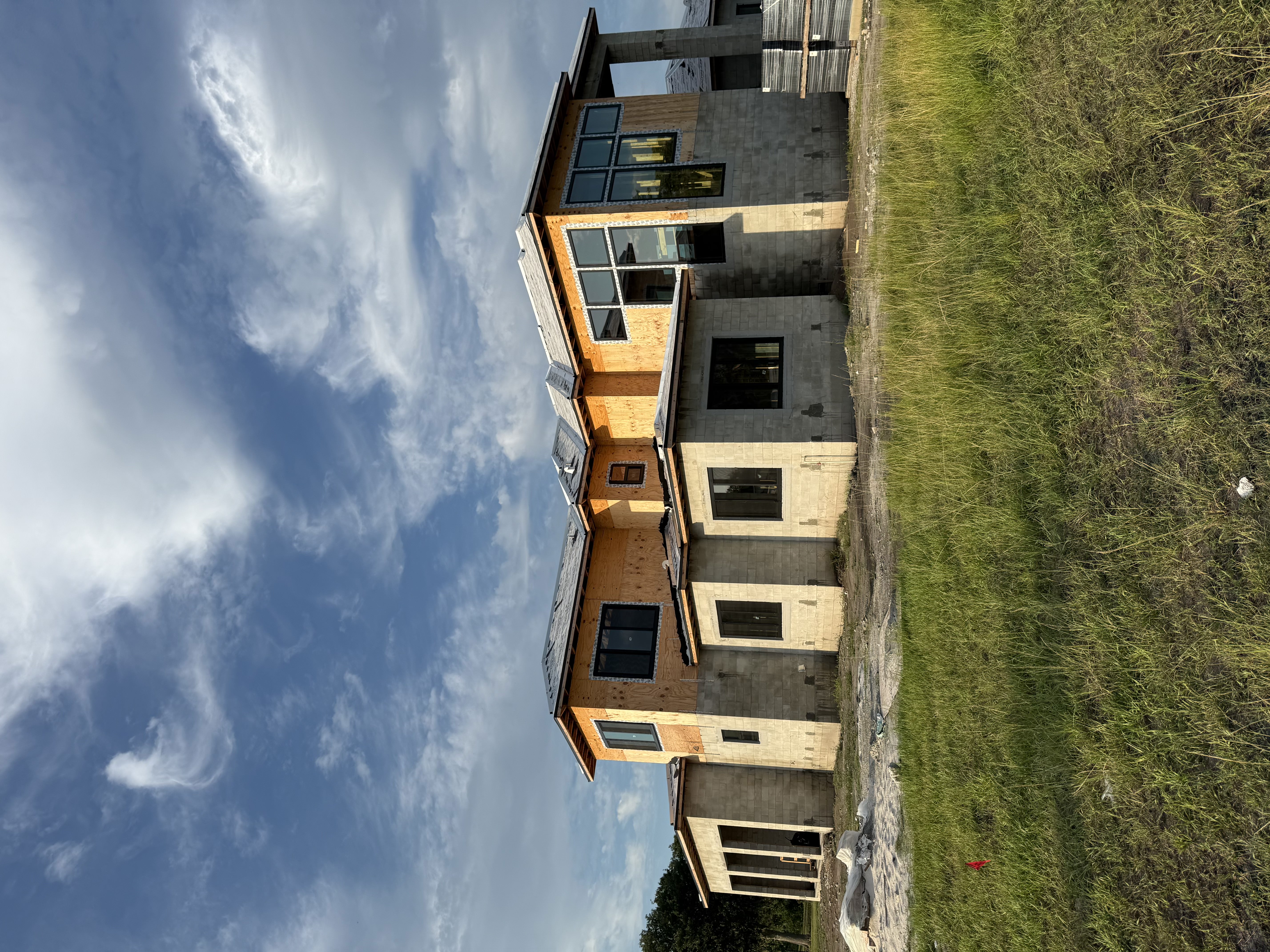 New modern home under construction with concrete walls and wooden framing.