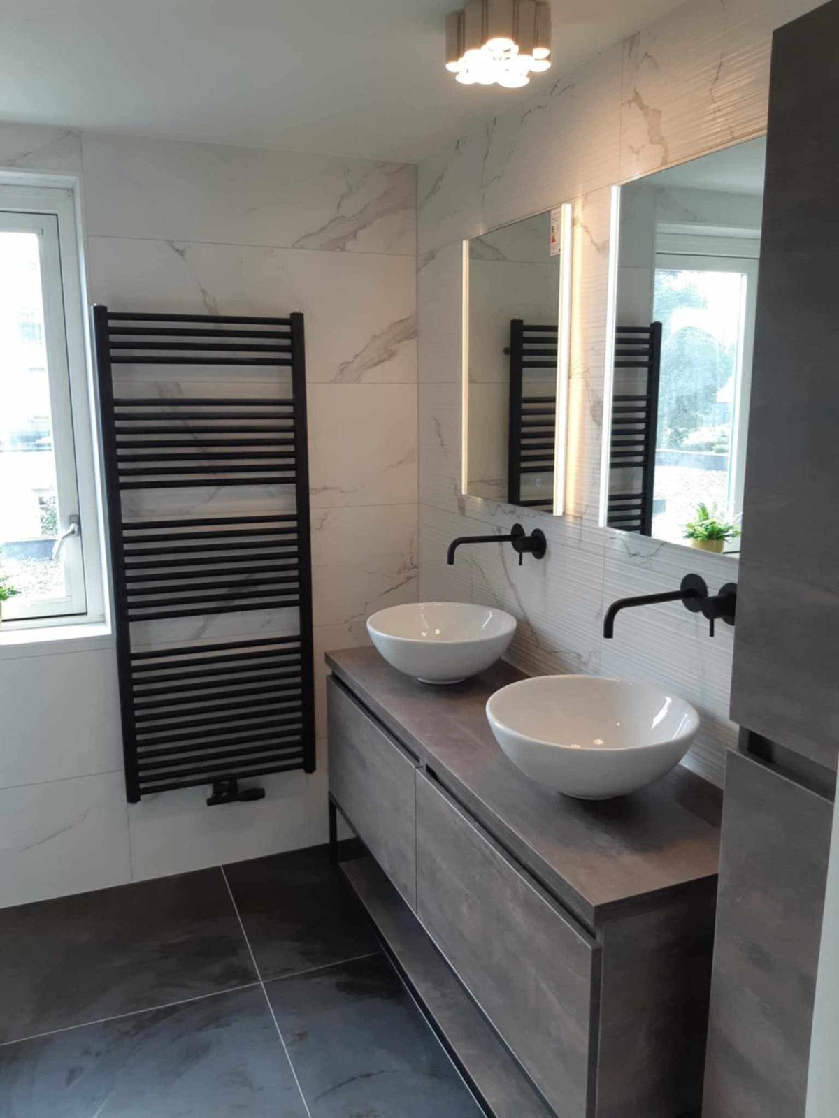 Salle de bains en marbre noir rénovée au Luxembourg : baignoire, meuble vasque bois, miroir LED.