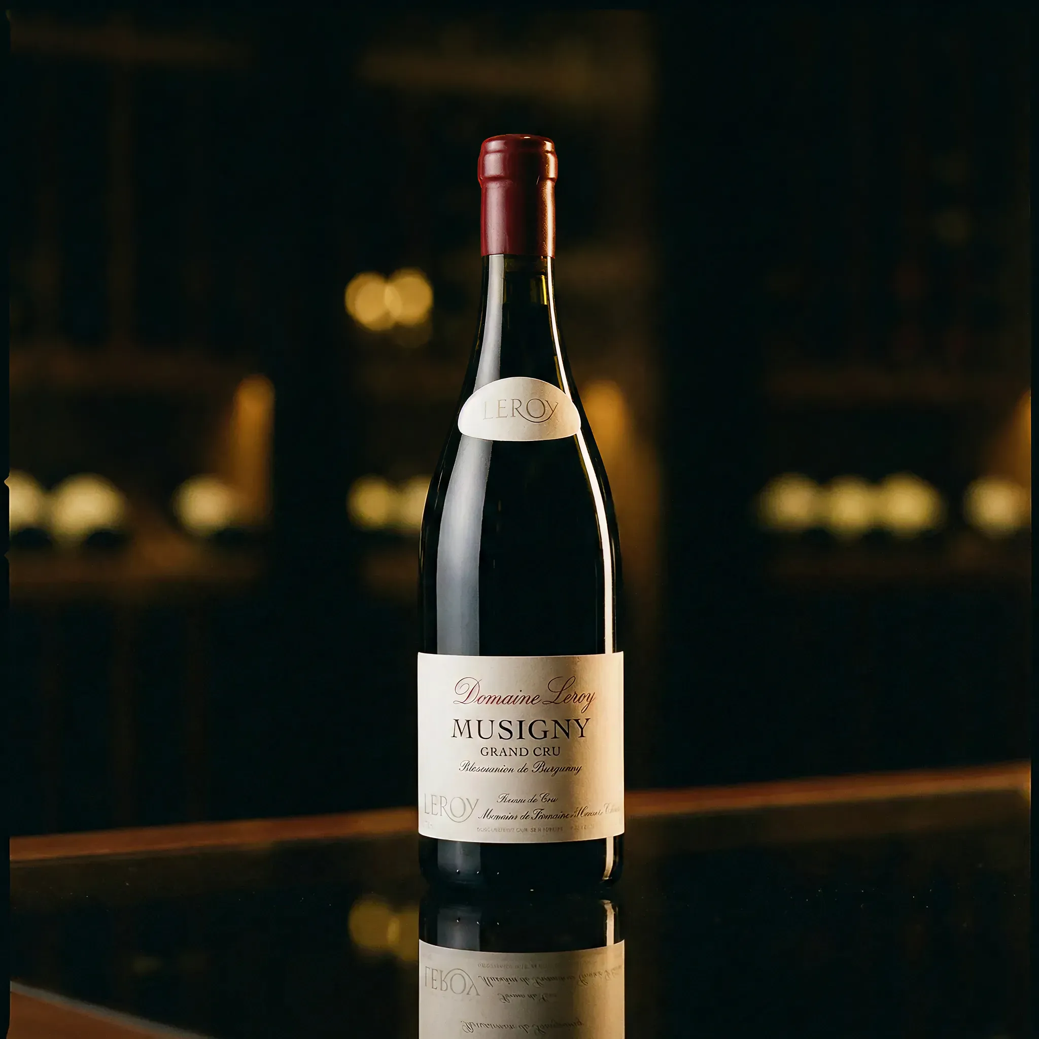 A wine bottle labeled "Domaine Leroy Musigny Grand Cru" stands on a reflective surface. The background is softly blurred, creating a warm, elegant ambiance.