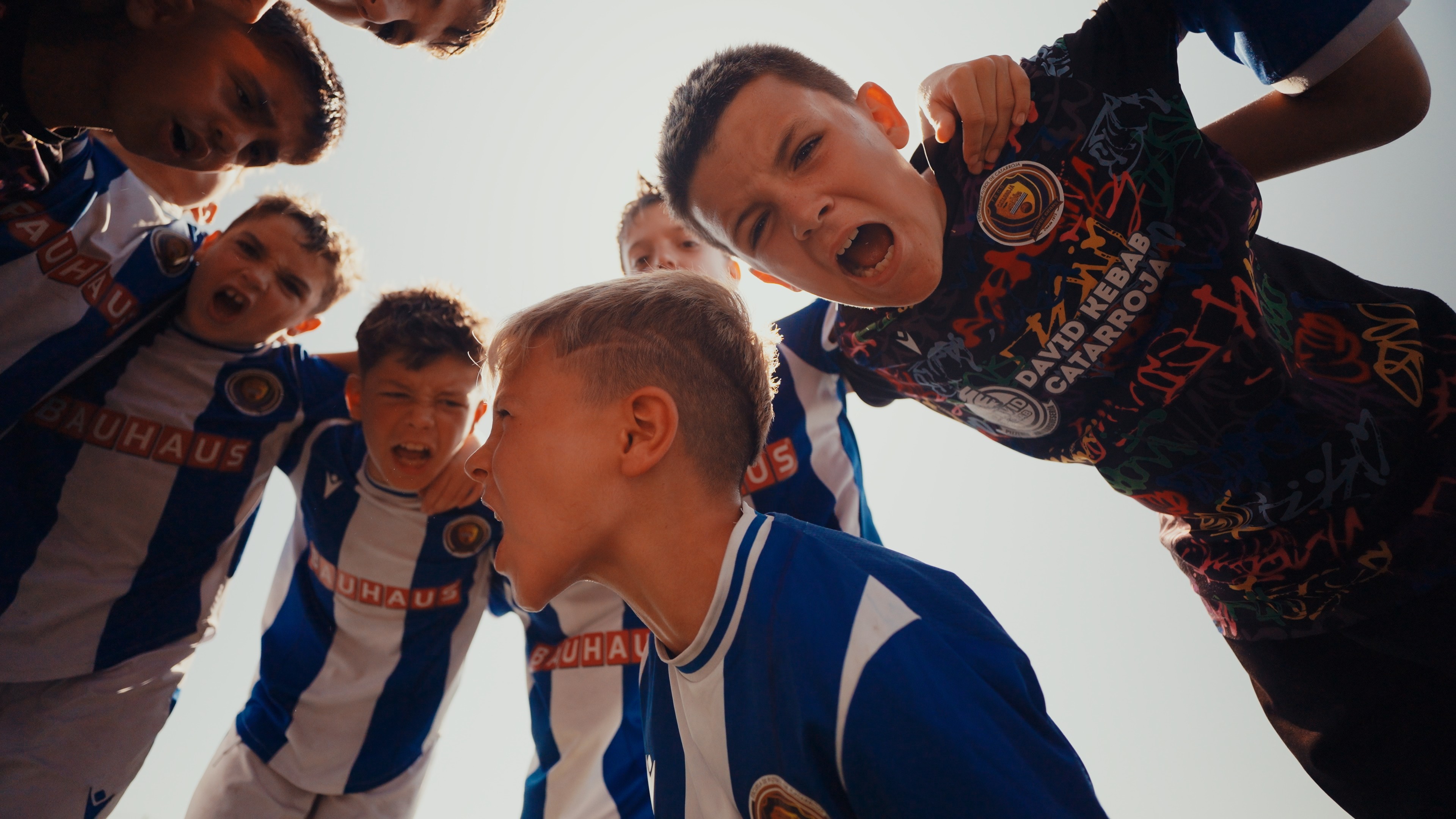 A woman wearing a shiny coat stands in focus, while a blurred background creates a sense of movement.