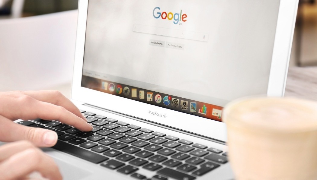 Close-up of hands researching online via Google, symbolising the information search phase of the customer journey.