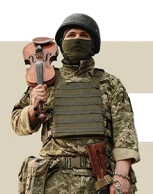 Військовий у формі ЗСУ, шоломі та оливковому бафі тримає на плечі скрипку.