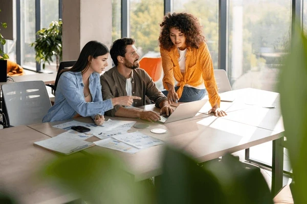 people collaborating at table modern workspace soft lighting