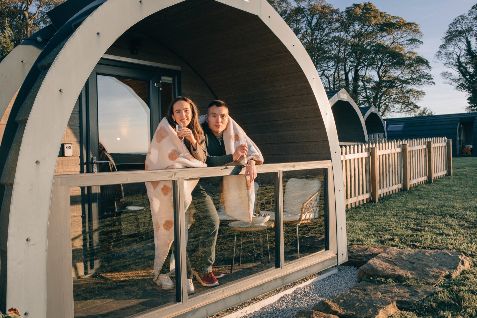 A couple at Eastfield glamping farm in golden hour