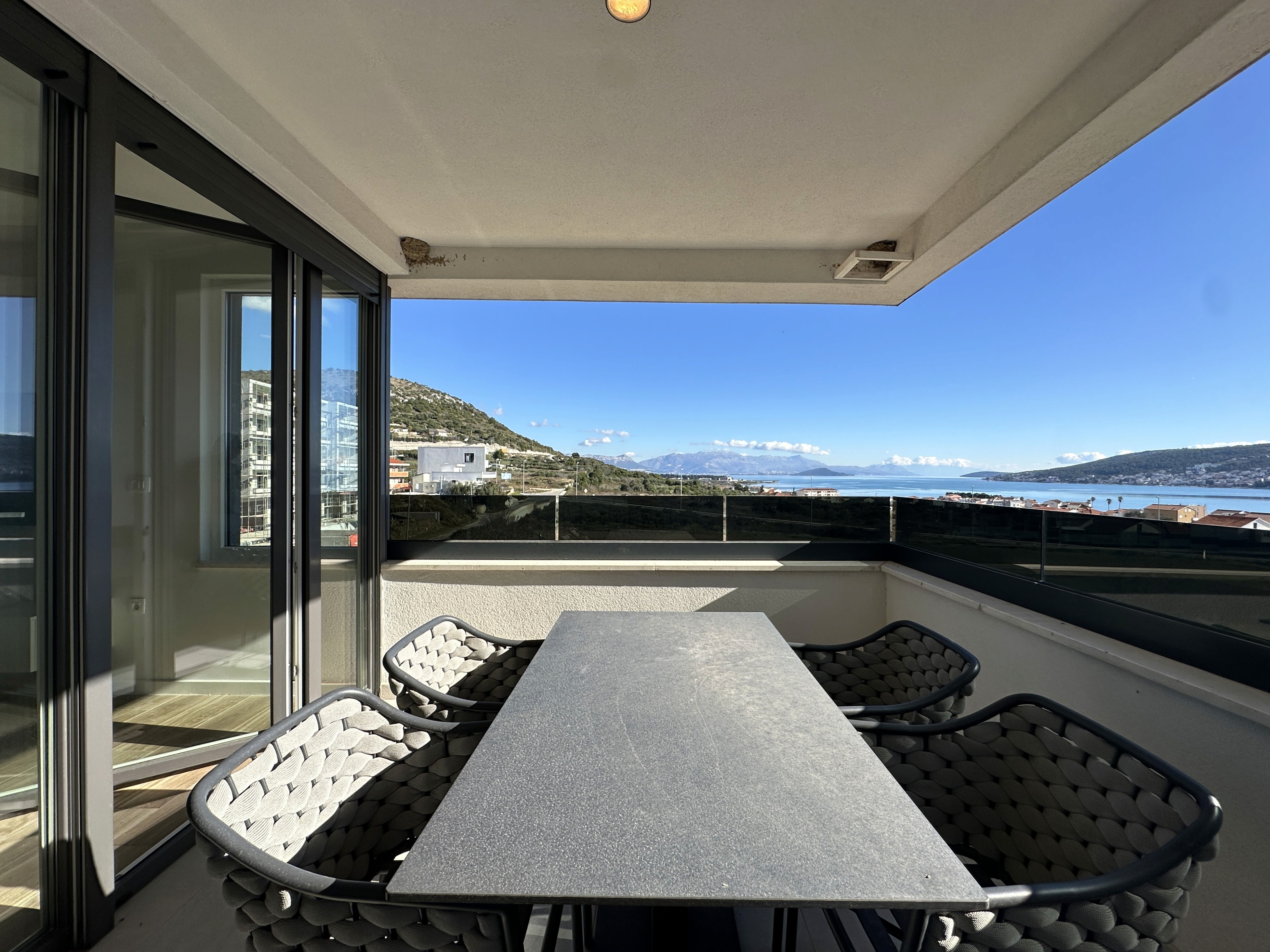 Black sports car in front of a modern, futuristic curved building.