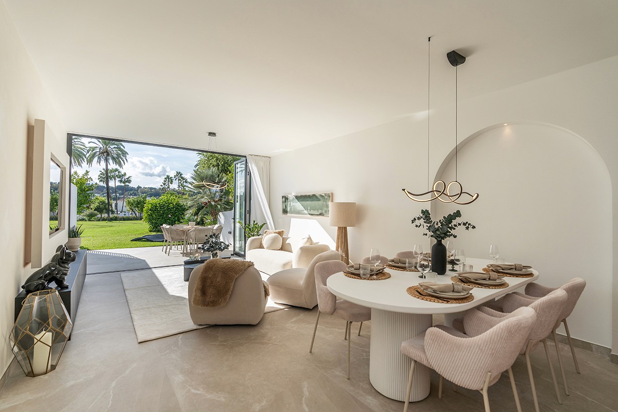 Modern open-plan living and dining area inside 'Casa Preciosa', featuring a contemporary fireplace and access to the terrace.