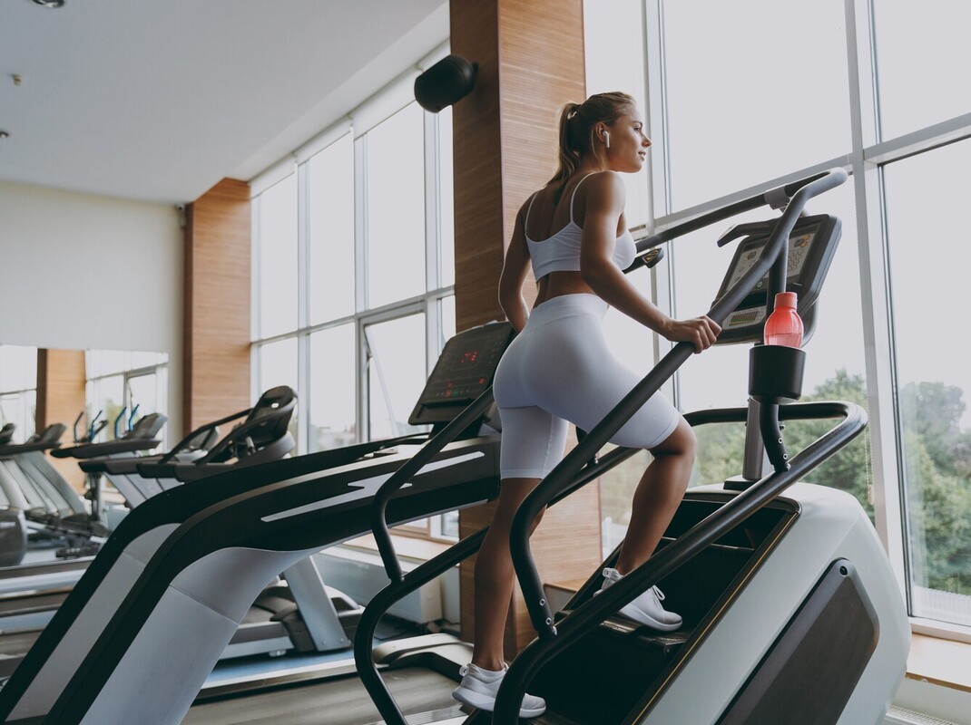 woman at the gym using a StairMaster instead of walking on treadmill to lose weight