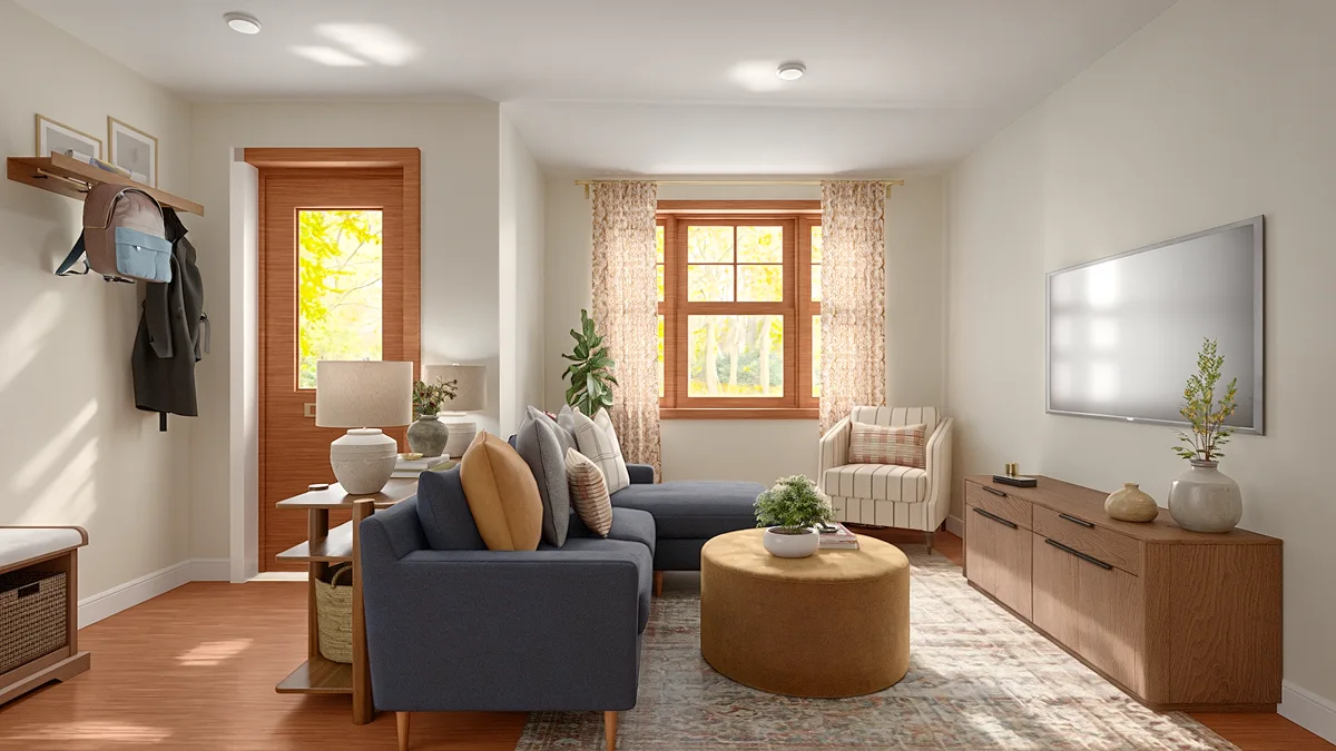 Living room with a navy sofa and TV, with a front door and entryway coat rack to the left.