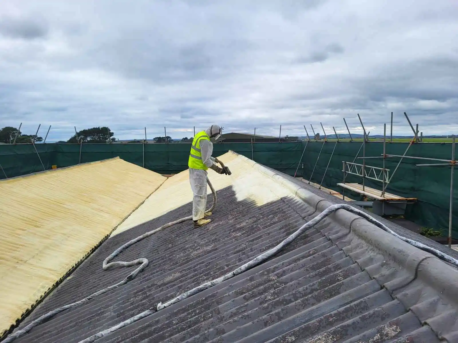 VP Foam Spray worker insulating asbestos roof with spray foam