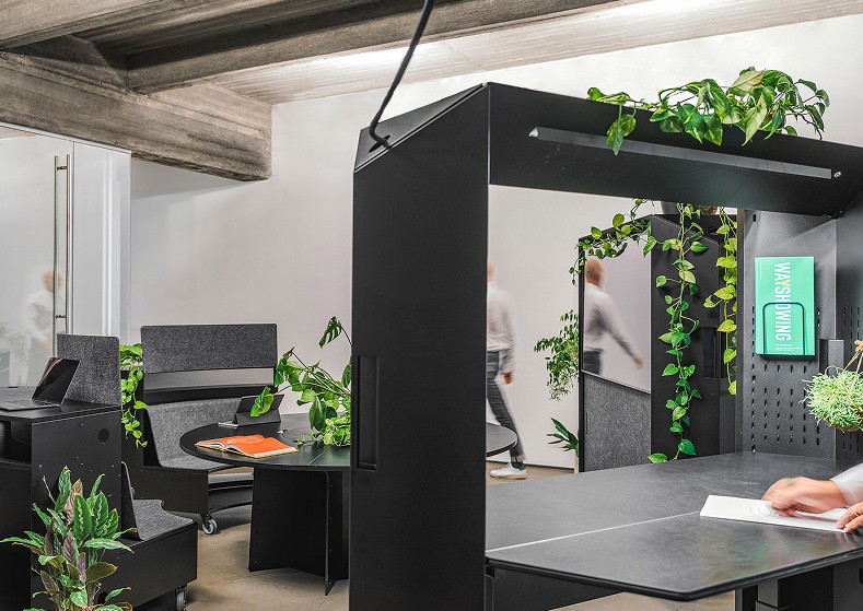 Modularer Büroraum mit dem flexiblen SCOPE System, inklusive Transformationswand mit Bildschirm, Steh-Arbeitsplatz, rundem Tisch, Pultbänken und vielen Pflanzen – gestaltet von Design for Human Nature in Hamburg.