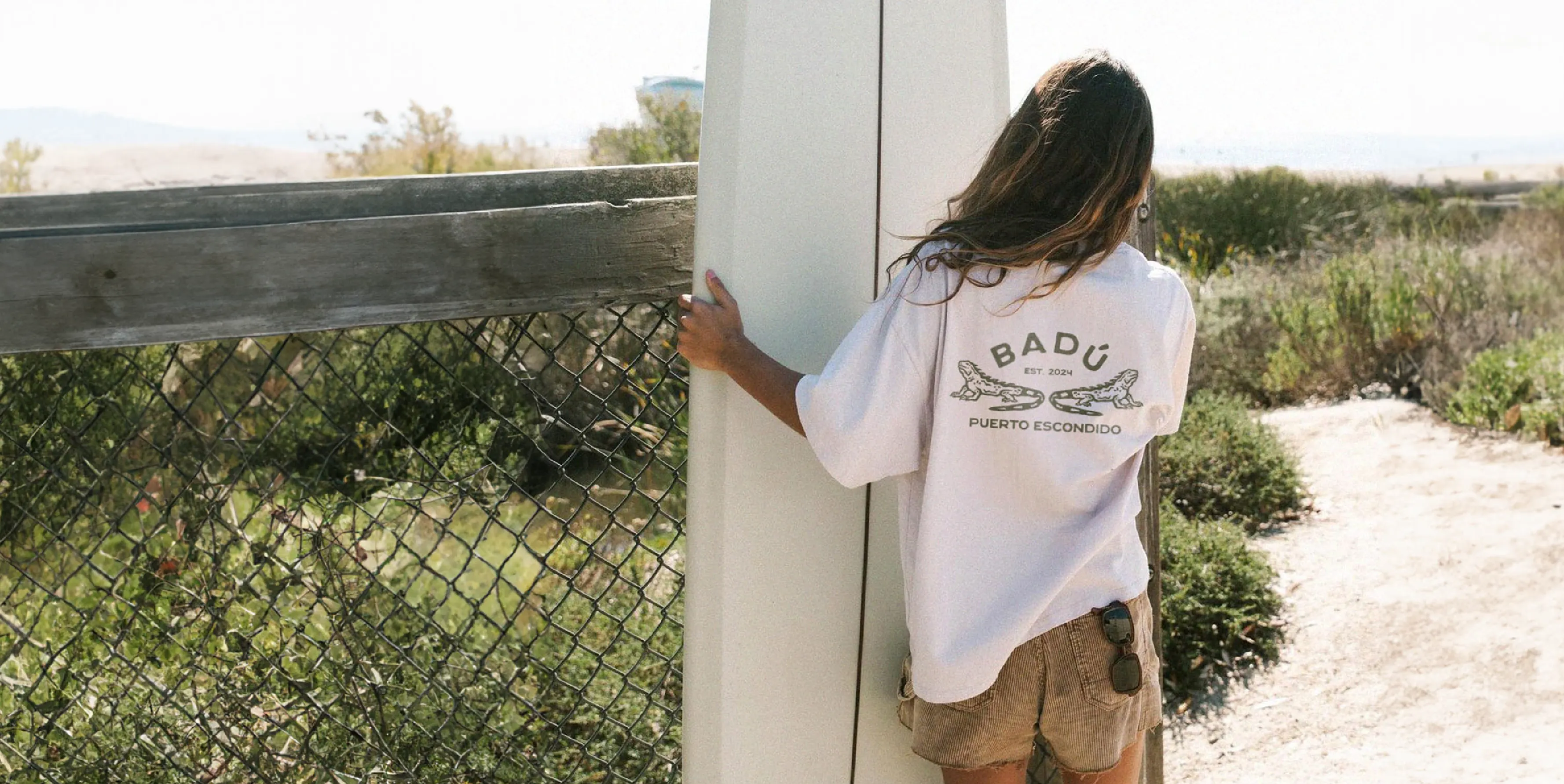 Badu printed t-shirt, worn by a female surfer at the beach
