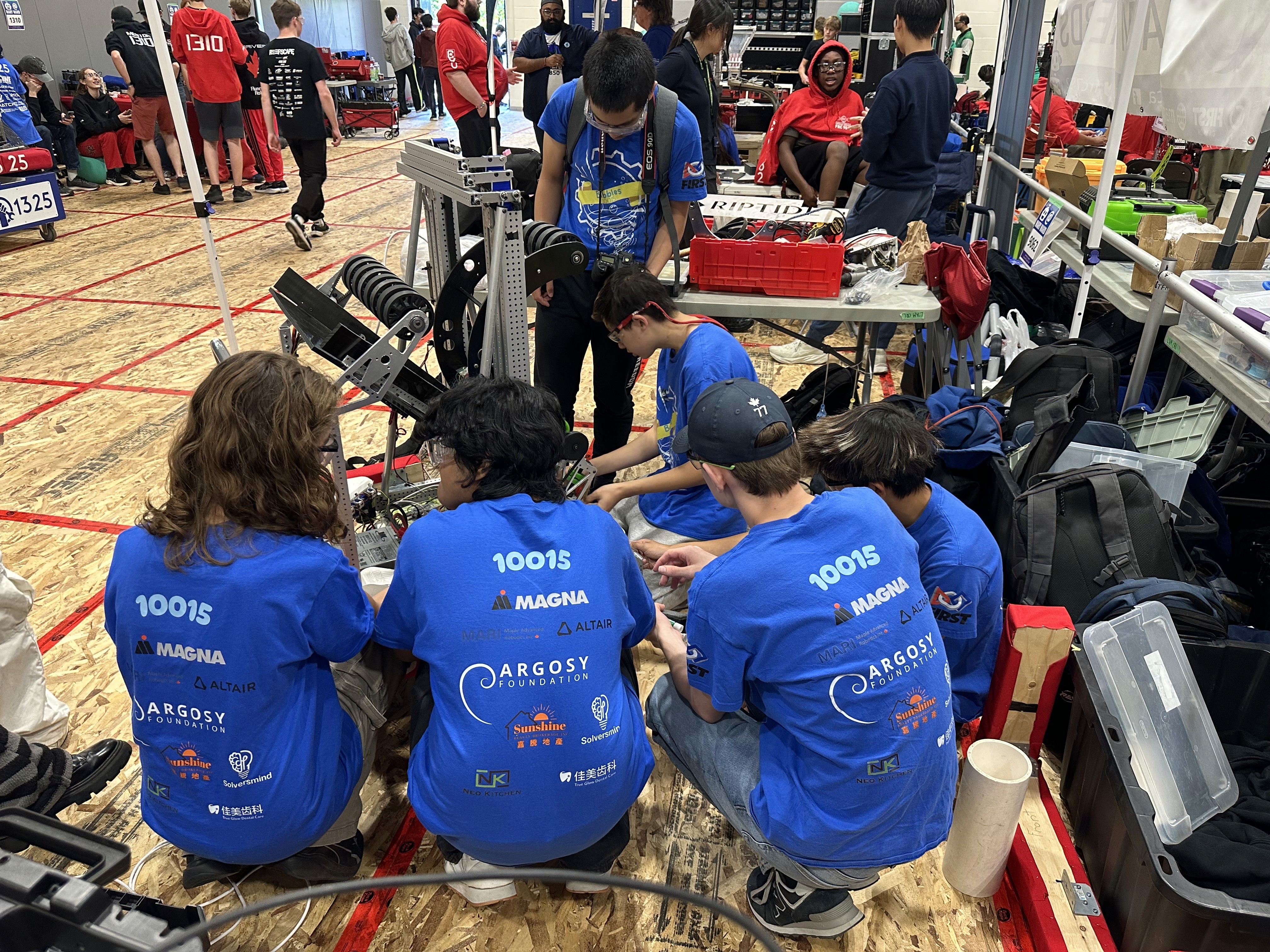 FRC 10015 Bubbles team captain Ryan Zhang troubleshoot the robot with the technical team.