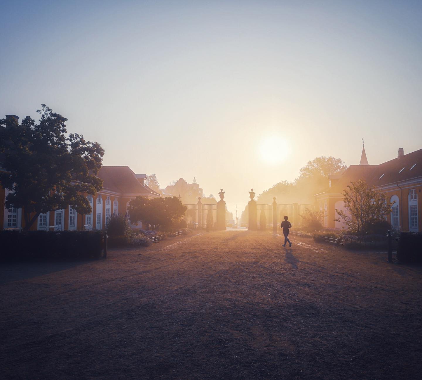 Someone jogging towards the gates of Frederiksberg Gardens in Copenhagen