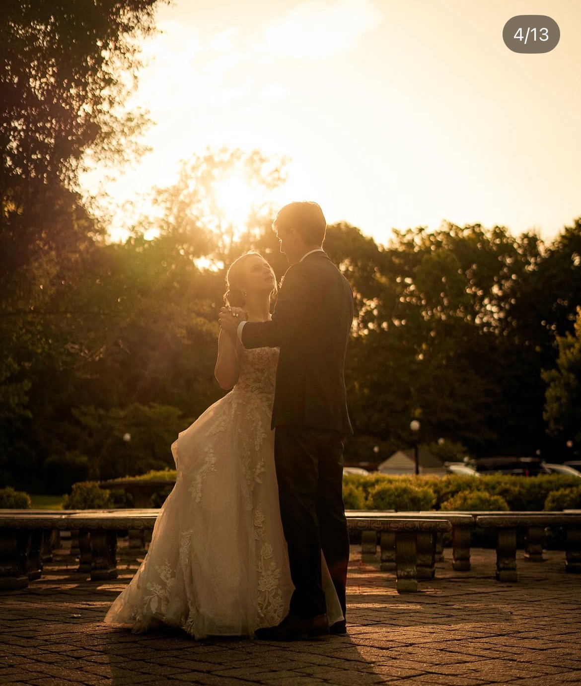 A bride and groom share a kiss surrounded by a joyful bridal party.