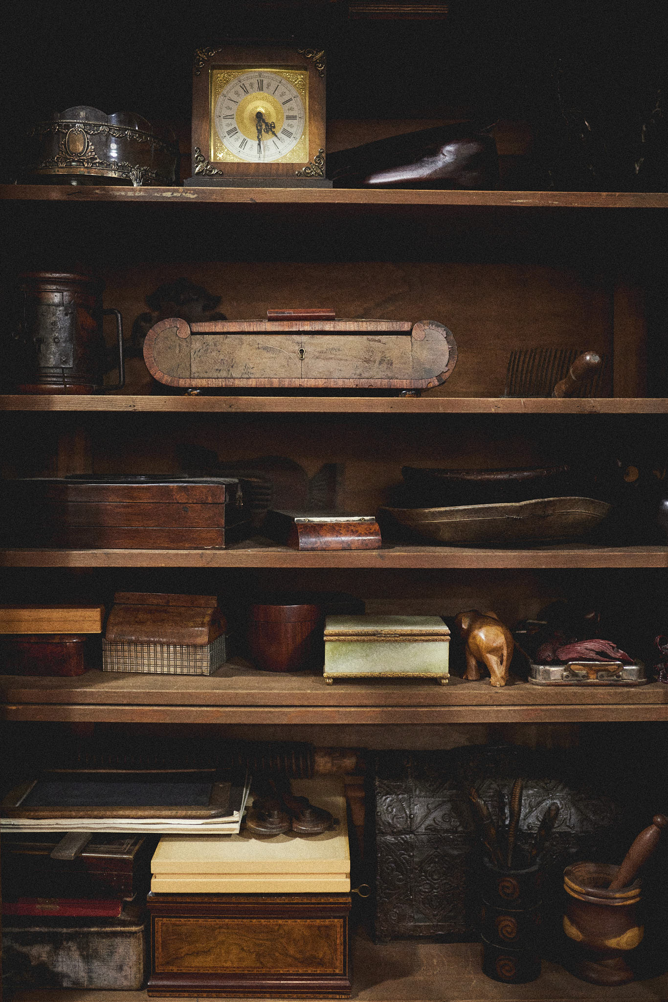A scene of a table filled with swatch books overlooking a shelf filled with ceramic vases