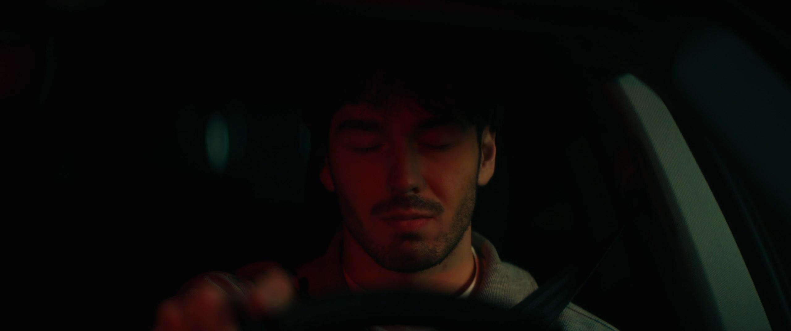 a man sits in a car with his eyes closed