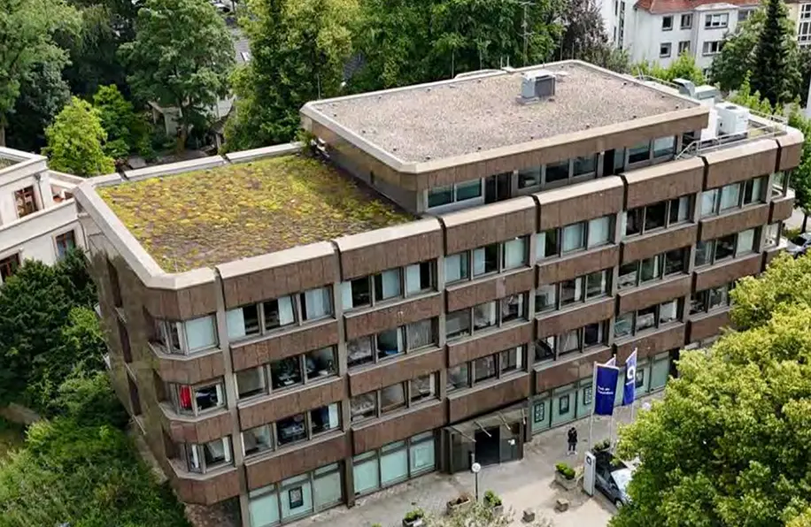 Isometrische Zeichnung eines Bauprojekts mit mehreren Gebäuden und markierten Strukturen in Rot