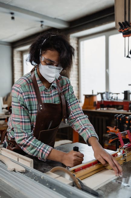 A female craftsman diligently working on a woodworking project in a workshop, surrounded by tools.