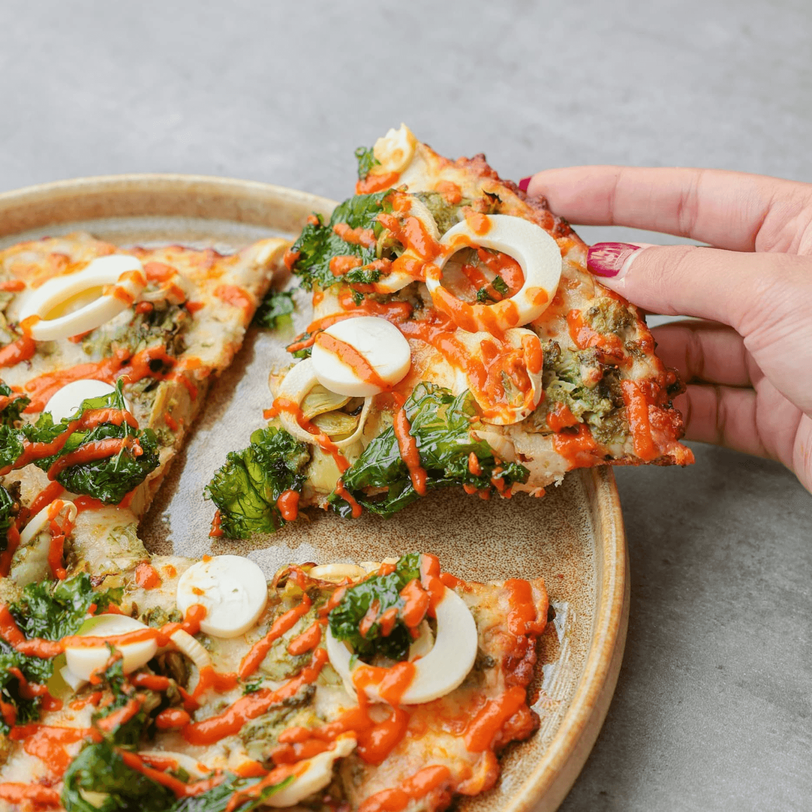 Vegetarian pizza topped with vegetables and egg slices on a plate.
