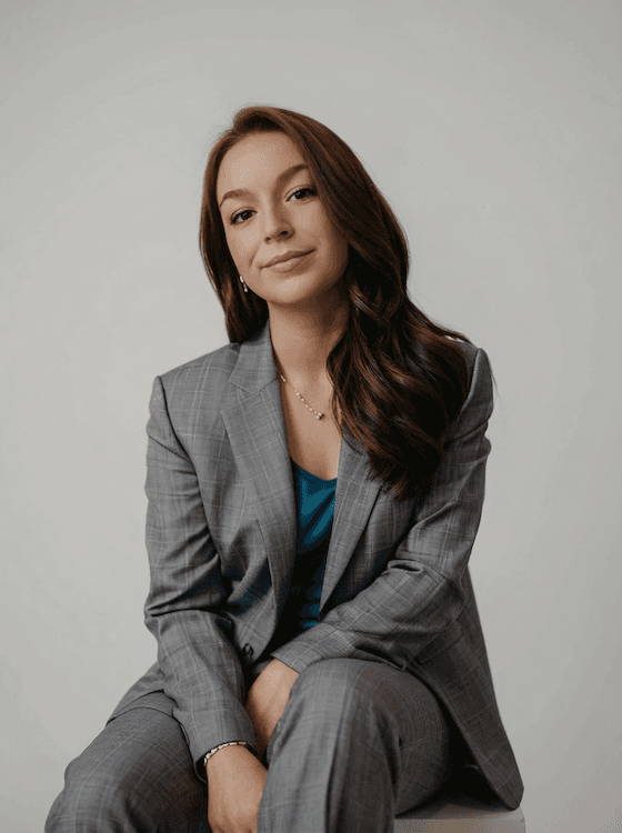 Portrait of a person in a pink sweater against a light background